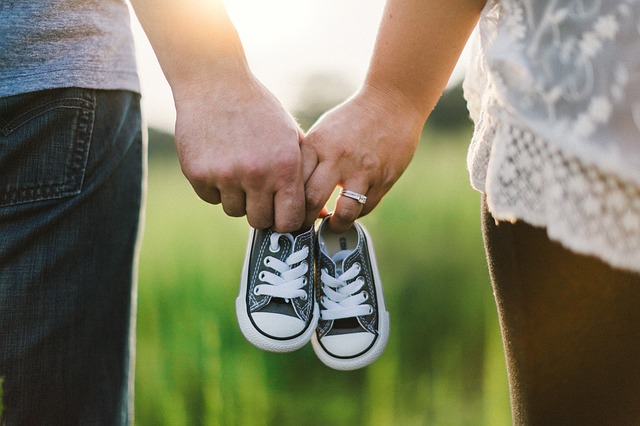 A couple holding baby shoes and preparing to start a family.