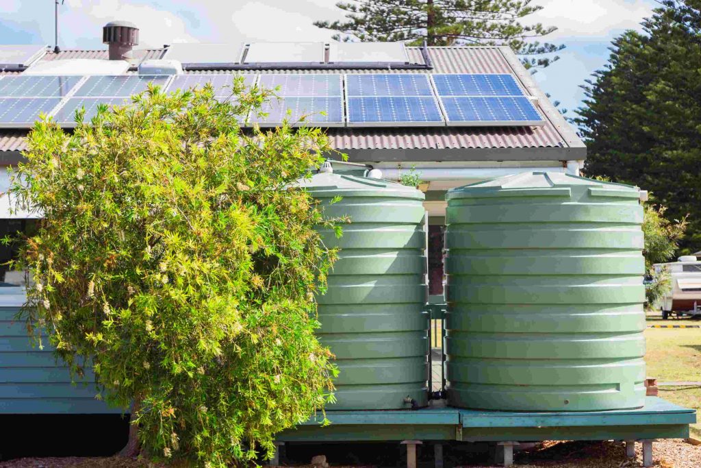 two green tanks outside house showing improvement of water efficiency at home